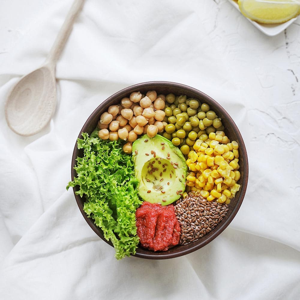 Salad bowl with chickpeas, peas, avocado, corn grains, seeds, tomato purée and lettuce from La Española Olive Oil Instagram 
